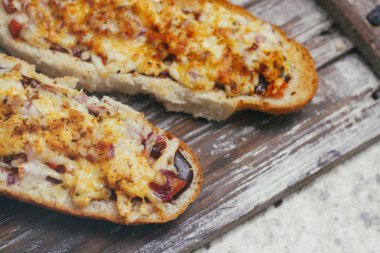 Peynir ve diğer karmaşık dolgu ile geleneksel Fransız bölünmüş baget bir çift. Ahşap retro arka plan standı tepsisinde.