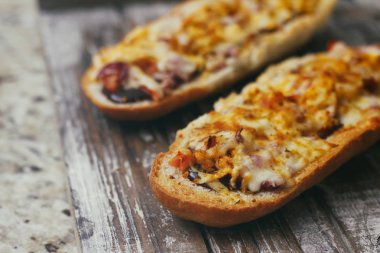 Peynir ve diğer karmaşık dolgu ile geleneksel Fransız bölünmüş baget bir çift. Ahşap retro arka plan standı tepsisinde.