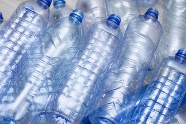 Mavi plastik şişeler konsept arka planı geri dönüştürür. Beyaz ın üzerine boş su şişeleri. Evcil hayvan ve ambalaj imalatı.