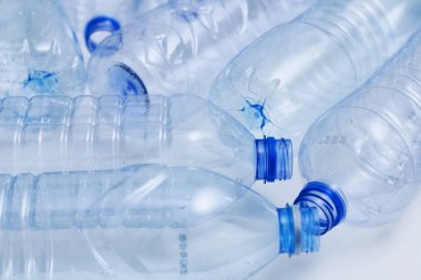 Mavi plastik şişeler konsept arka planı geri dönüştürür. Beyaz ın üzerine boş su şişeleri. Evcil hayvan ve ambalaj imalatı.