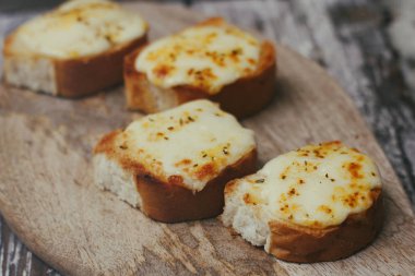 Ahşap gıda standında peynir ve baharat ile bruschetta seti. Taze dolgu ve kızarmış gevrek kabuk ile dilimlenmiş fransız baget. 