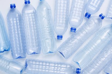 Mavi plastik şişeler konsept arka planı geri dönüştürür. Beyaz ın üzerine boş su şişeleri. Evcil hayvan ve ambalaj imalatı.