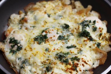 Kızartma tavası üzerinde mini tost, yeşillik ve peynir ile çırpılmış yumurta. Pişirme işlemi. 