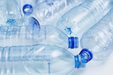 Mavi plastik şişeler konsept arka planı geri dönüştürür. Beyaz ın üzerine boş su şişeleri. Evcil hayvan ve ambalaj imalatı.