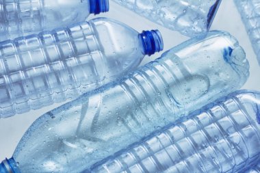 Mavi plastik şişeler konsept arka planı geri dönüştürür. Beyaz ın üzerine boş su şişeleri. Evcil hayvan ve ambalaj imalatı.