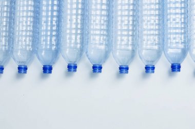 Mavi plastik şişeler konsept arka planı geri dönüştürür. Beyaz ın üzerine boş su şişeleri. Evcil hayvan ve ambalaj imalatı.