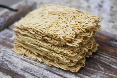 Ahşap masa üzerinde kuru çiğ anlık yumurta erişte seti. Pişirmeye hazır. Sarı geleneksel erişte. Wok. Asya mutfağı.  