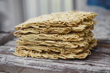 Ahşap masa üzerinde kuru çiğ anlık yumurta erişte seti. Pişirmeye hazır. Sarı geleneksel erişte. Wok. Asya mutfağı.  