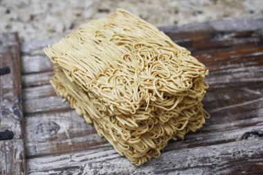 Ahşap masa üzerinde kuru çiğ anlık yumurta erişte seti. Pişirmeye hazır. Sarı geleneksel erişte. Wok. Asya mutfağı.  