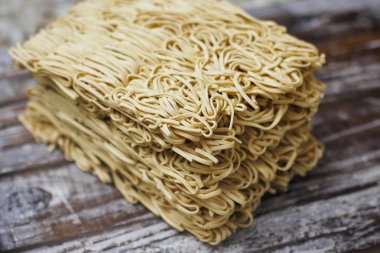 Ahşap masa üzerinde kuru çiğ anlık yumurta erişte seti. Pişirmeye hazır. Sarı geleneksel erişte. Wok. Asya mutfağı.  