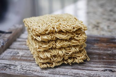 Ahşap masa üzerinde kuru çiğ anlık yumurta erişte seti. Pişirmeye hazır. Sarı geleneksel erişte. Wok. Asya mutfağı.  