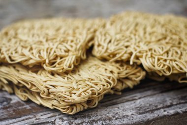 Ahşap masa üzerinde kuru çiğ anlık yumurta erişte seti. Pişirmeye hazır. Sarı geleneksel erişte. Wok. Asya mutfağı.  