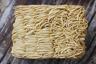 Ahşap masa üzerinde kuru çiğ anlık yumurta erişte seti. Pişirmeye hazır. Sarı geleneksel erişte. Wok. Asya mutfağı.  