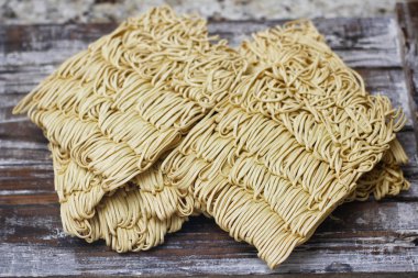 Ahşap masa üzerinde kuru çiğ anlık yumurta erişte seti. Pişirmeye hazır. Sarı geleneksel erişte. Wok. Asya mutfağı.  