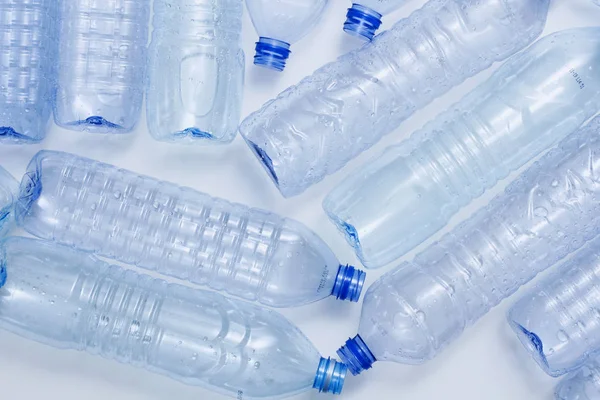 Mavi plastik şişeler konsept arka planı geri dönüştürür. Beyaz ın üzerine boş su şişeleri. Evcil hayvan ve ambalaj imalatı.