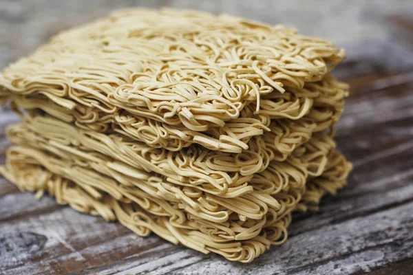 Ahşap masa üzerinde kuru çiğ anlık yumurta erişte seti. Pişirmeye hazır. Sarı geleneksel erişte. Wok. Asya mutfağı.  