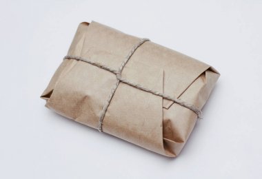 Kutu parsel beyaz arka plan üzerinde kenevir kablosu bağlı kahverengi zanaat kağıt sarılmış. 