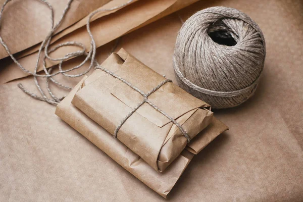 Present wrapped to brown craft paper and tied by cord. Parcel for send. Shop package.