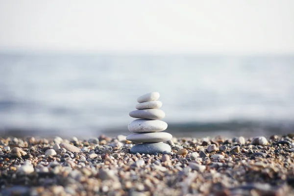 Stones tower with blurred sea background. Pyramid on the center. Zen garden. Spa set.