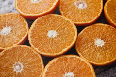 Tahta masaüzerinde taze dilimlenmiş portakal. Meyve yarım.