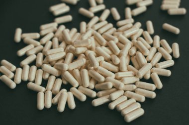 Beyaz kapsüller tozlu haplar. Siyah arkaplanda. 