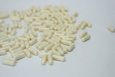 Bir sürü hap seti. Beyaz arka planda sarı kapsüller. Sağlık desen kavramı.