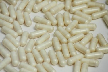 Bir sürü hap seti. Beyaz arka planda sarı kapsüller. Sağlık desen kavramı.