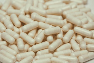 Bir sürü hap seti. Beyaz arka planda sarı kapsüller. Sağlık desen kavramı.