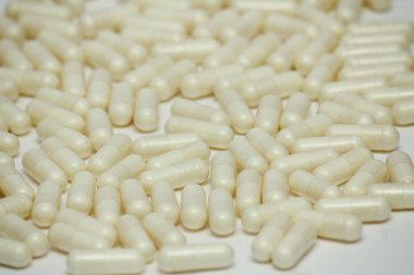 Bir sürü hap seti. Beyaz arka planda sarı kapsüller. Sağlık desen kavramı.