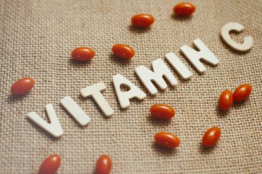 Tuval bez doku arka plan üzerinde ahşap harflerle C vitamini kavram metni.