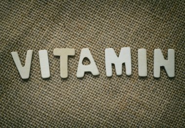 Tuval bez doku arka plan üzerinde ahşap harflerle C vitamini kavram metni.