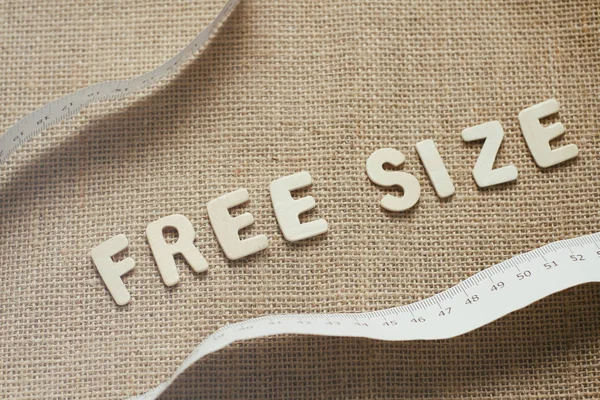 Free size text by wooden letters on cloth background. Measuring tape. Diet and detox concept.