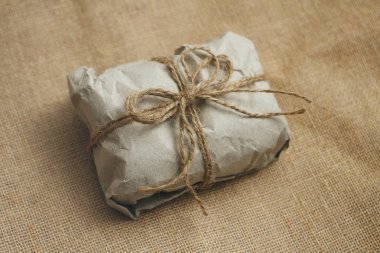 Parsel kahverengi zanaat kağıt içine sarılmış. eski bez arka plan dokusu. Kese kravat pamuk dize. 