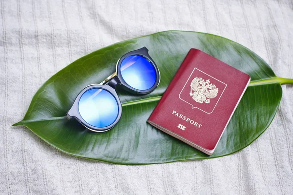 Rosyjski Paszport Niebieskimi Okulary Przeciwsłoneczne Świeżym Zielonym Liściem Koncepcja Podróżowania — Zdjęcie stockowe