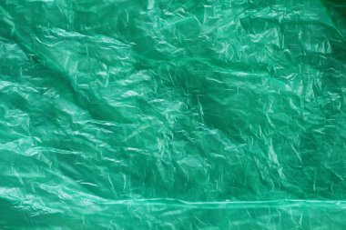 Yeşil buruşturulmuş plastik torba doku arka plan. Atık geri dönüşüm konsepti. Polietilen berrak çöp torbaları. 