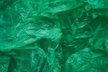 Yeşil buruşturulmuş plastik torba doku arka plan. Atık geri dönüşüm konsepti. Polietilen berrak çöp torbaları. 