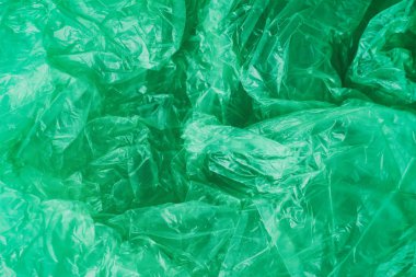 Yeşil buruşturulmuş plastik torba doku arka plan. Atık geri dönüşüm konsepti. Polietilen berrak çöp torbaları. 