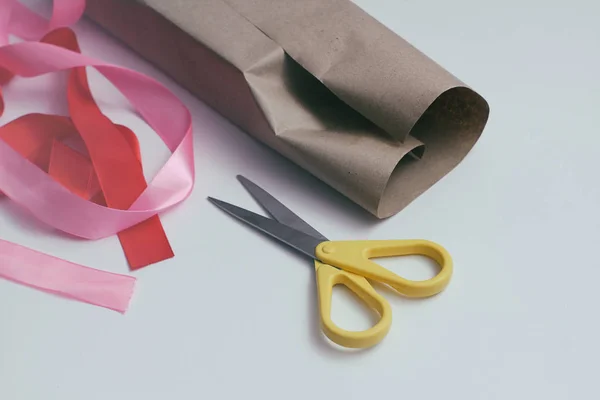 Gift package set. Craft paper, red and pink tapes, scissors. White background.