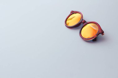 beyaz zemin üzerine kırmızı güneş gözlüğü.