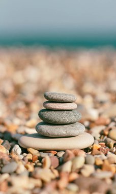 Bulanık plaj arka plan üzerinde Taş zen piramit. Sıcak yaz fotoğrafı. Sakin ve dinlenme yeri. Spa terapisi geçmişi. Metin alanı.