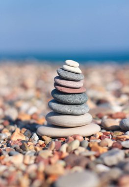 Bulanık plaj arka plan üzerinde Taş zen piramit. Sıcak yaz fotoğrafı. Sakin ve dinlenme yeri. Spa terapisi geçmişi. Metin alanı.