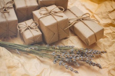 Kahverengi hediye kutuları seti. Zanaat kağıt sarılmış ve kenevir kablosu ile bağlı. Eski kağıt arka plan. Küçük lavanta buketi. 