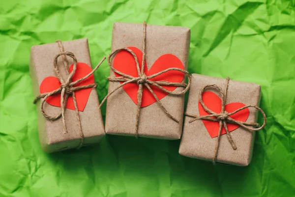 三套礼品盒 用绳子绑在绿色碎纸背景上 纸箱心卡 — 图库照片