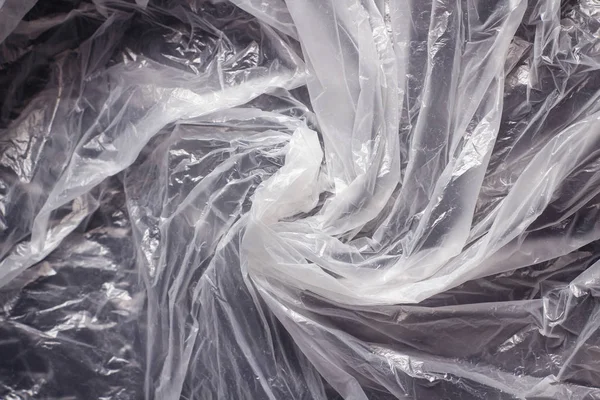 Transparent plastic bag swirl. Whirlpool from clear plastic bag. Background texture. Waste recycle. Reuse of trash.