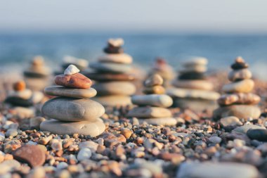 Bulanık deniz arka plan üzerinde spa taşları Zen piramit. Sahilde kum. Deniz kıyıları. Metin için yer.
