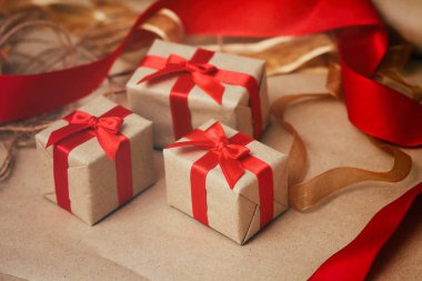 Zanaat kağıt sarılmış hediye kutuları seti ve kravat kırmızı saden kurdele. Noel hediyeleri. Tatil havası. Yeni yıl dekoru.