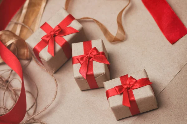 一套用工艺纸包裹的礼品盒 系上红缎丝带 圣诞礼物假日气氛 新年装饰 — 图库照片