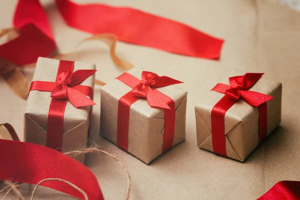 一套用工艺纸包裹的礼品盒 系上红缎丝带 圣诞礼物假日气氛 新年装饰 — 图库照片