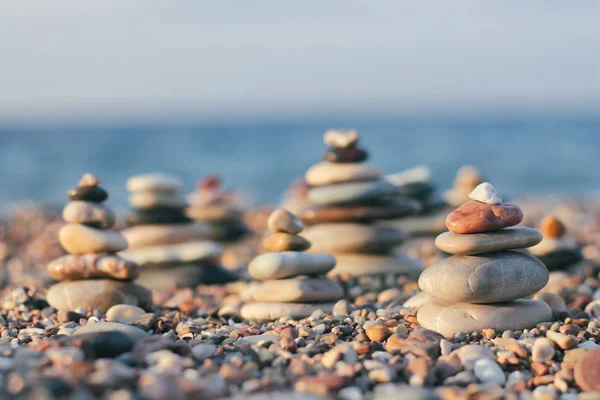 Zen pyramid of spa stones on the blurred sea background. Sand on a beach. Sea shores. Place for text.Sea view.