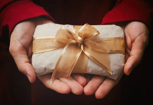 Hediye kutusunu elele tut. Mevcut zanaat kağıt ve sain kurdele sarılmış. Kızların elinde küçük bir paket. Noel zamanı. Tatil havası.